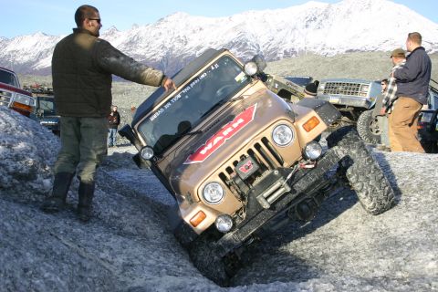 2003 Jeep TJ - A Jeep TJ navigates a challenging icy terrain, with onlookers observing the off-road adventure.