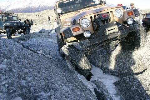 2003 Jeep TJ - Two Jeep TJs tackle a challenging icy terrain with snowy mountains in the background.