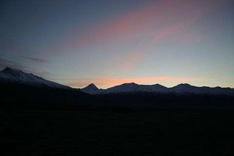 2003 Jeep TJ - The sun sets behind a mountain range, casting a dark silhouette over the foreground.