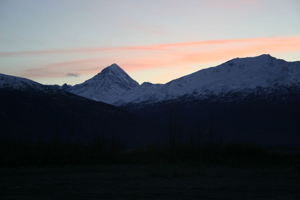 snowy mountain peaks against a pink and blue sky at sunset