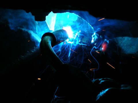 2003 Jeep TJ - Welding a metal pipe with intense blue light and flying sparks.