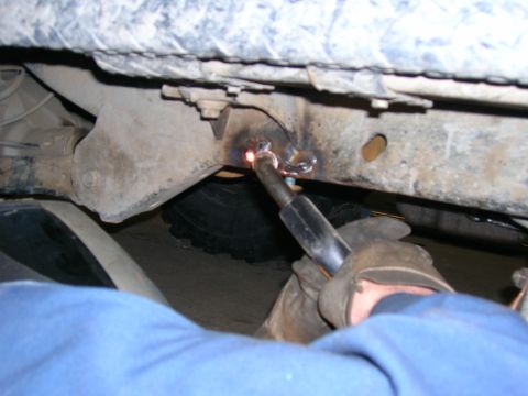 2003 Jeep TJ - A mechanic welds a repair onto the frame of a 2003 Jeep TJ, indicating a section repair.