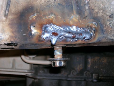 2003 Jeep TJ - This photo shows a close-up of a welded repair on a vehicle's frame, with a bolt and washer visible.