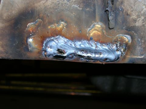 2003 Jeep TJ - Close-up view of a metal frame section showing multiple crude welds and signs of heat damage.