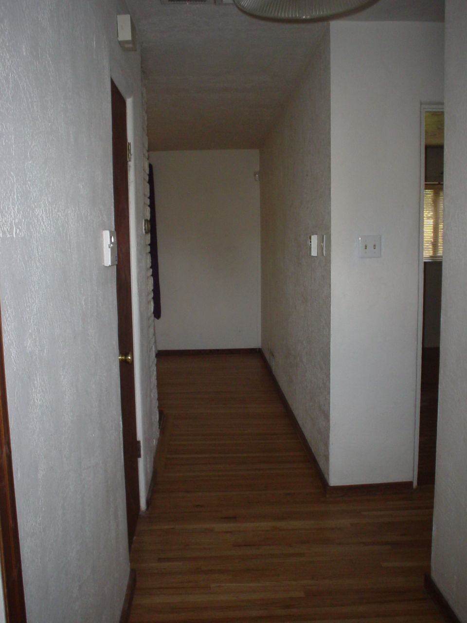 Interior hallway with wood floor and textured walls