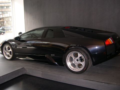 2003 Jeep TJ - Rear three-quarter view of a black Lamborghini Murciélago, likely from the early 2000s.