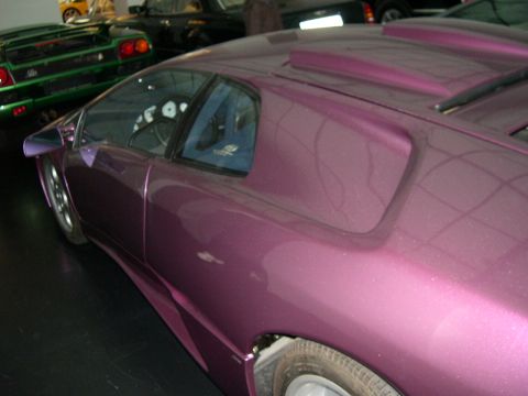 2003 Jeep TJ - A purple sports car is seen from a 3/4 front angle, with other vehicles in the background.