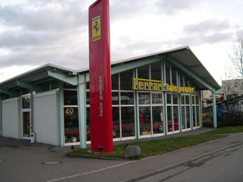 2003 Jeep TJ - Exterior view of a Ferrari dealership, a prominent red sign and showroom windows displaying vehicles.