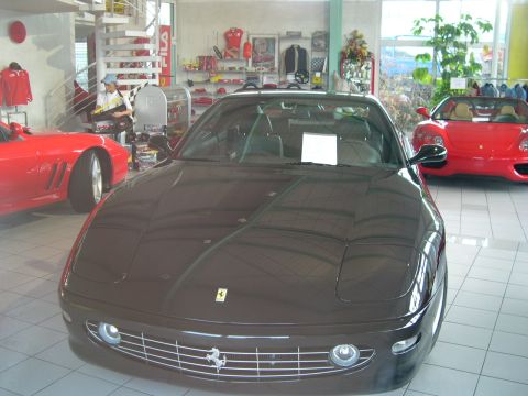 2003 Jeep TJ - A dark brown Ferrari 456 GT is displayed in a showroom alongside a red Ferrari.