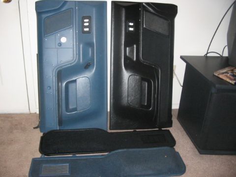 1991 Ford Bronco - Two vehicle door panels and carpet pieces are laid out on the floor.