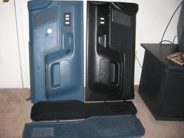 Two vehicle door panels, one blue and one black, with carpet pieces below