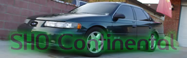 1993 Ford Taurus - A 1993 Ford Taurus SHO is parked outside a garage with a brick wall in the background.