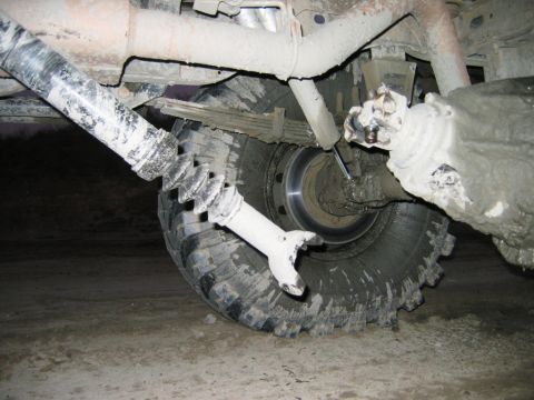 1985 Ford Bronco - The rear axle and driveshaft of a 1985 Ford Bronco have detached and are covered in mud.