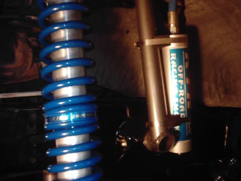 1978 Ford Bronco - Two off-road shock absorbers are visible, one with a blue coil spring and the other with a blue label.