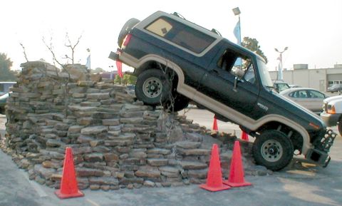 1983 Ford Bronco - This Ford Bronco is navigating a challenging rock obstacle, demonstrating its off-road capabilities.