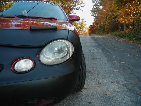 1997 Ford Taurus - Front view of a red car partially covered by a black bra, with "HONDA MOTORSPORTS" visible on the windshield.