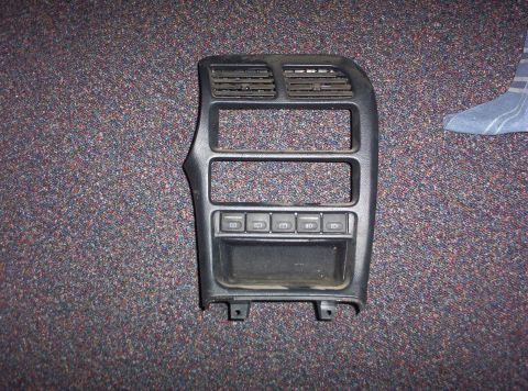 1994 Ford Probe - This black interior trim panel features air vents and several buttons, likely for a car's dashboard.