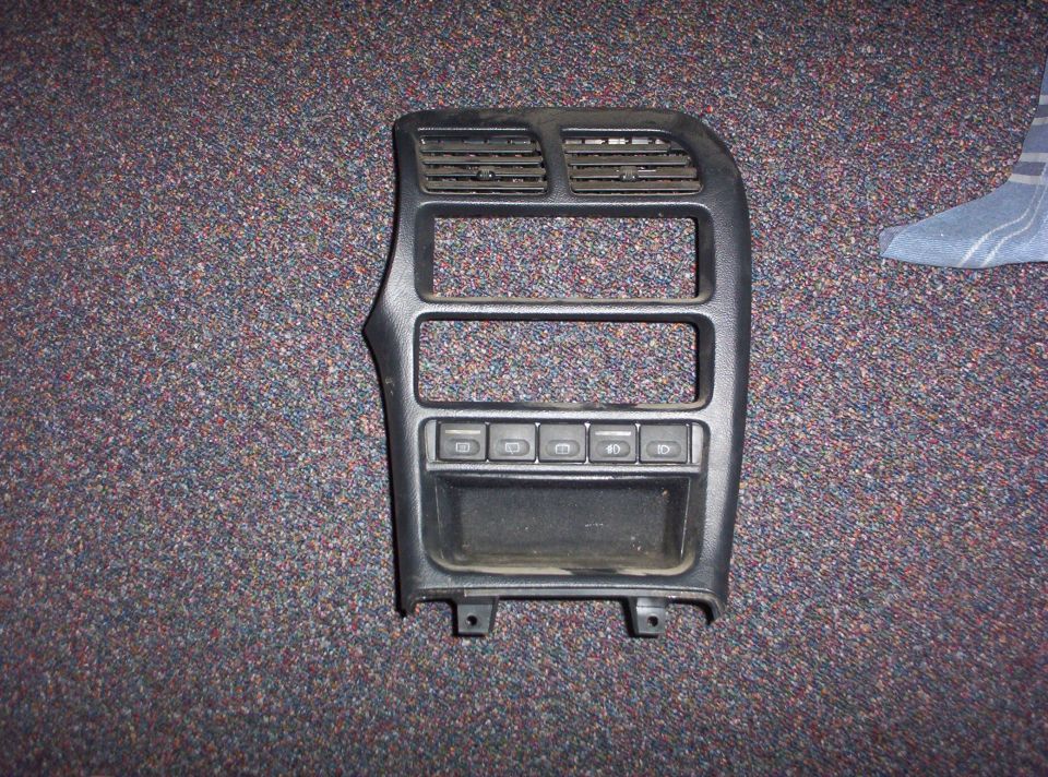 Black interior trim panel with air vents and buttons
