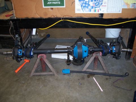 1983 Ford Bronco - A disassembled Dana 44 axle assembly is shown, with various components and tools scattered around.