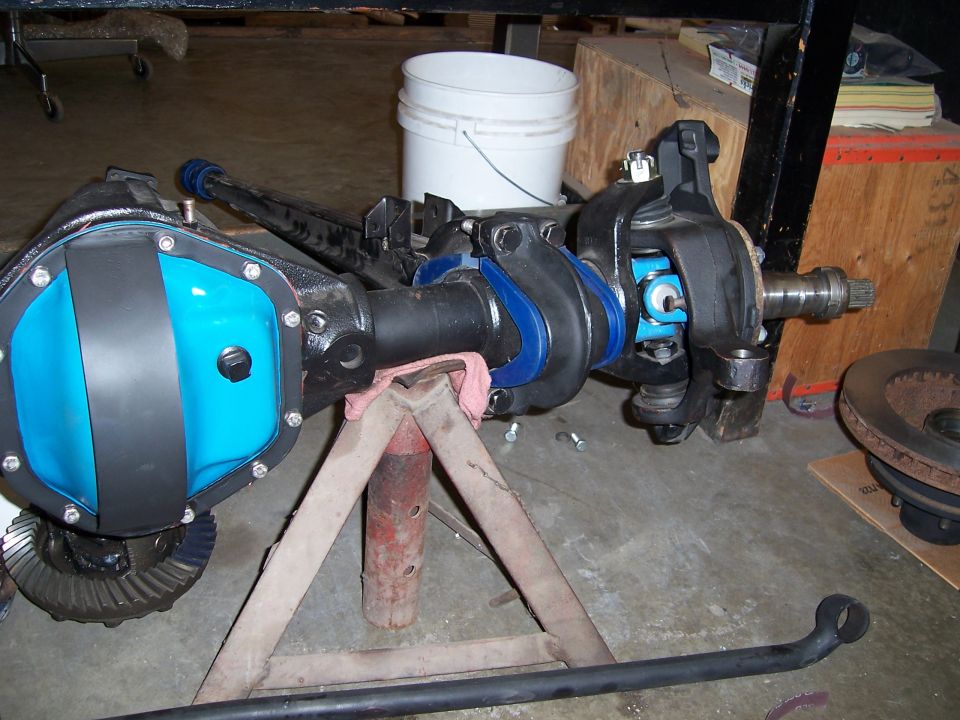 Dana 44 front axle assembly with blue differential cover, supported by a jack stand