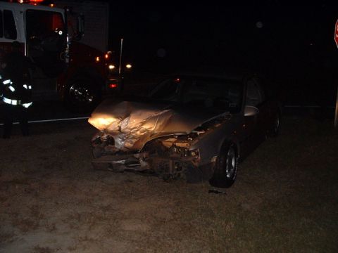 1989 Ford Thunderbird - Front end of a wrecked 1989 Ford Thunderbird at night, with a fire truck visible in the background.