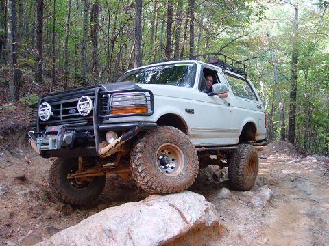 1996 Ford Bronco - This 1996 Ford Bronco is tackling a challenging off-road course in a wooded area.