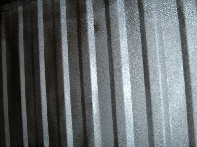 Vertically ribbed corrugated metal surface in gray tones