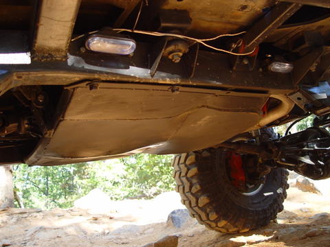 1996 Ford Bronco - The underside of a vehicle is visible, a skid plate and a large tire.