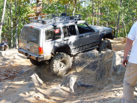 1996 Ford Bronco - This Jeep Cherokee XJ is navigating a difficult rocky obstacle on an off-road trail.