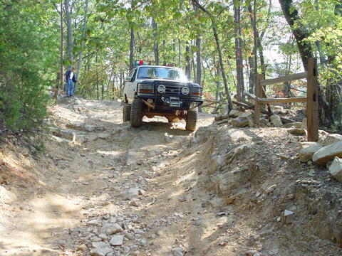 1996 Ford Bronco - This truck is navigating a challenging off-road course with steep inclines and loose rocks.