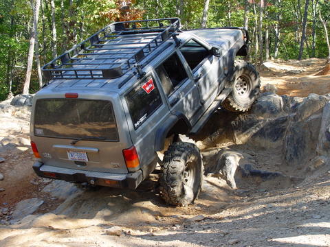 1996 Ford Bronco - This Jeep Cherokee XJ is navigating a challenging rocky terrain on an off-road trail.