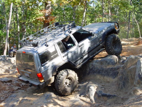 1996 Ford Bronco - This modified Jeep Cherokee XJ navigates a challenging rocky terrain during an off-road excursion.