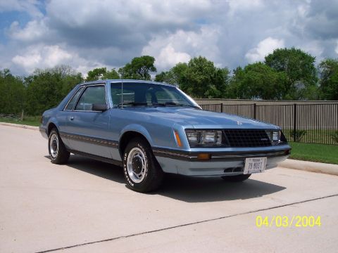 1982 Ford Mustang - This blue coupe, identified by its license plate as a 1979 Mustang, is shown from a 3/4 front angle.