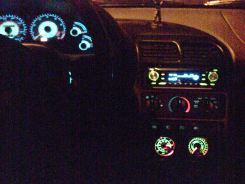 1997 Ford Probe - The dashboard of a 1997 Ford Probe is illuminated at night, with glowing gauges and a car stereo.