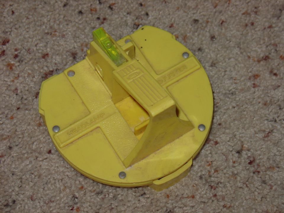 Yellow plastic part with a bubble level and text that reads 'HEADLAMP'