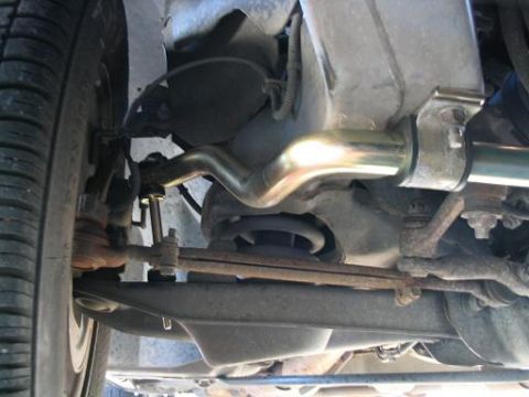 1999 Ford Crown Victoria - Close-up view of the front suspension components and tire of a vehicle.