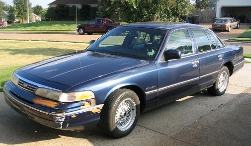Blue 1994 Ford Crown Victoria, 3/4 front view, showing damage to front bumper