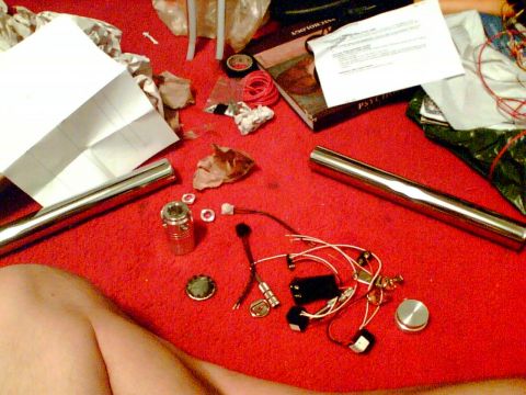 1997 Ford Probe - Automotive parts including exhaust pipes and electrical components are laid out on a red carpet.
