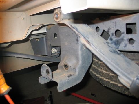 2004 Ford F-150 - Underside view of truck frame and suspension components, showing a bracket and part of a tire.