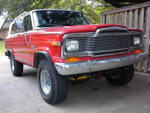 1993 Ford Bronco - This Jeep Cherokee features a prominent chrome grille and a two-tone red and white paint scheme.