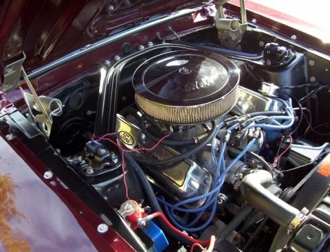 1969 Ford Mustang - Engine bay detail showing a Ford V8 engine with aftermarket chrome air cleaner and blue spark plug wires.
