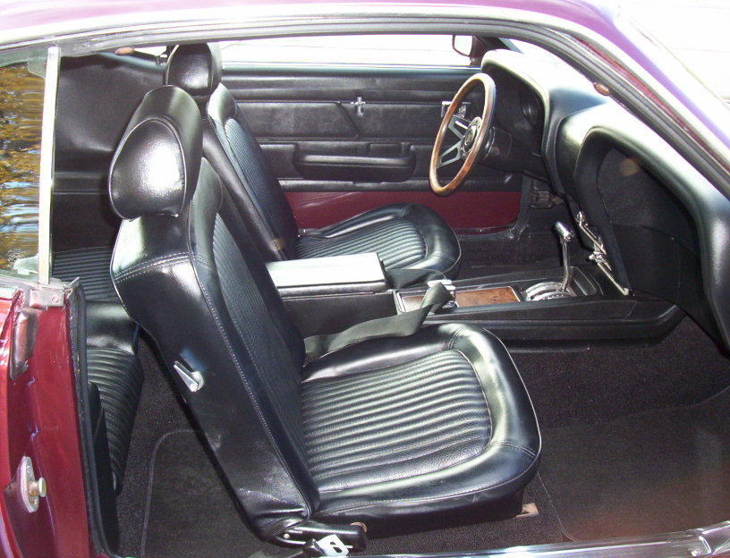 Front seats, dashboard, steering wheel, and center console of a classic car