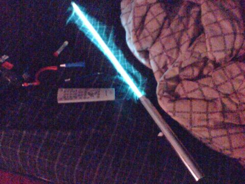1997 Ford Probe - A prop light saber glows blue, with a remote and wires nearby.