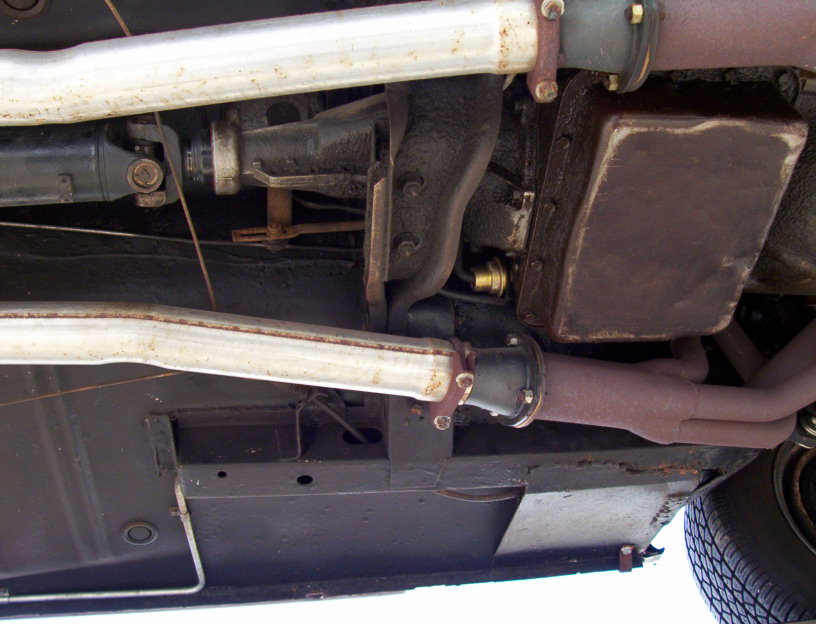 Vehicle undercarriage showing dual exhaust pipes, frame rail and fuel tank