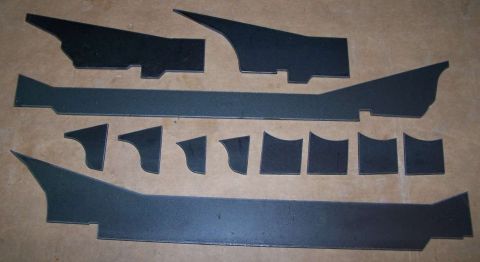 1979 Ford Bronco - Several custom cut metal parts are arranged on a textured background.