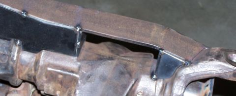 1979 Ford Bronco - Detail of a vehicle's undercarriage, showing frame modifications and mechanical parts.