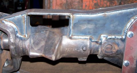1979 Ford Bronco - A close-up view shows a metal component of a vehicle's frame with visible welds and a stamped part number.