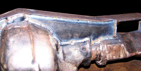 1979 Ford Bronco - A heavily welded metal frame component shows signs of repair and age, with rust and discoloration evident.