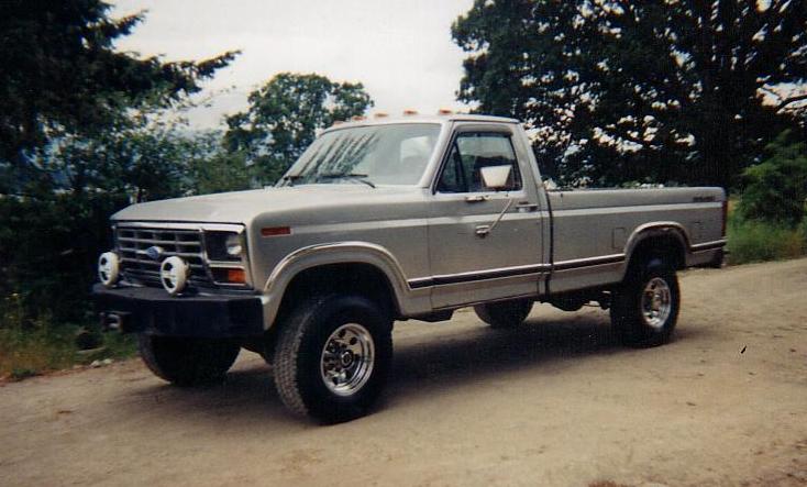 Silver Ford regular cab pickup with black bumper, round fog lights and alloy wheels on a gravel road