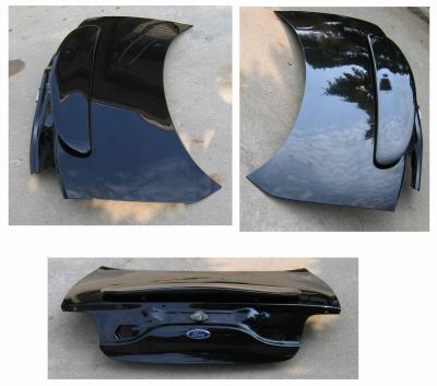 2000 Ford Taurus - Three angles of a glossy black painted Ford trunk lid with embossed oval emblem, photographed laid out on a sunny driveway.